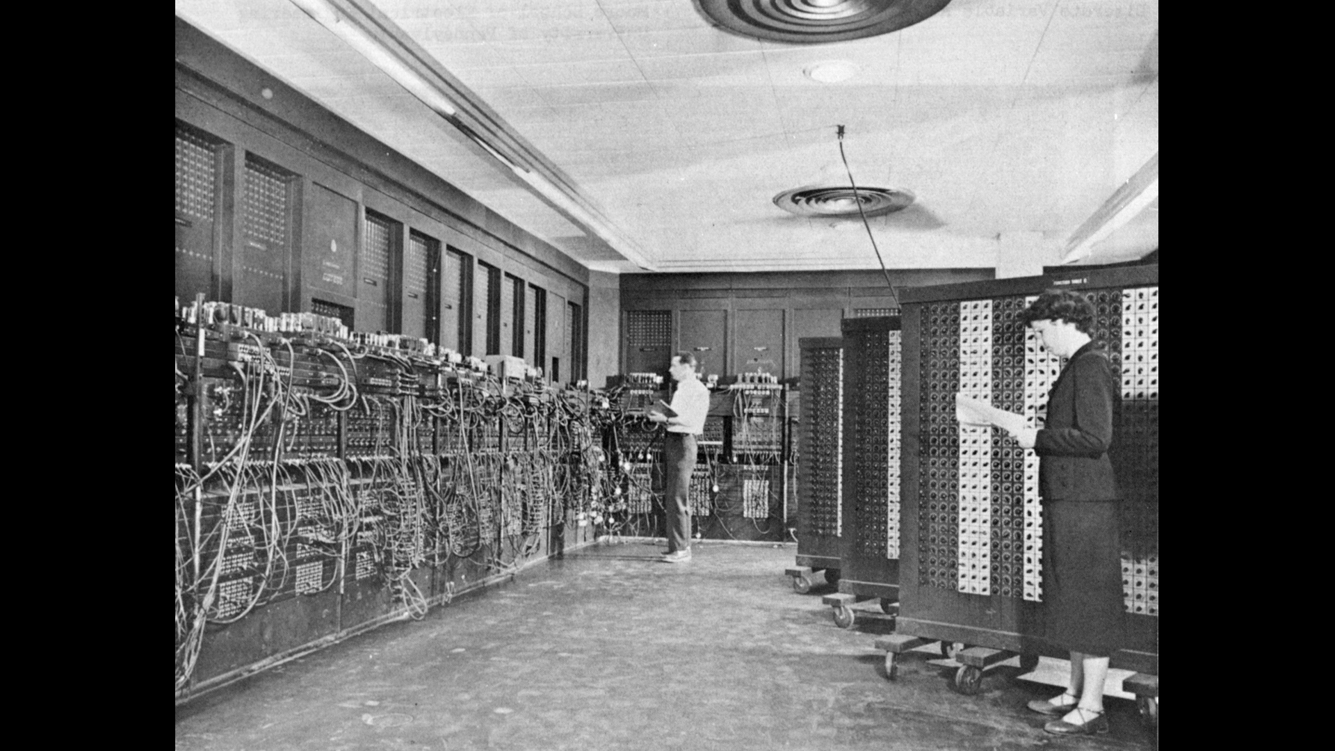 Glen Beck (background) and Betty Snyder (foreground) program ENIAC in BRL building 328. (U.S. Army photo, ca. 1947-1955)